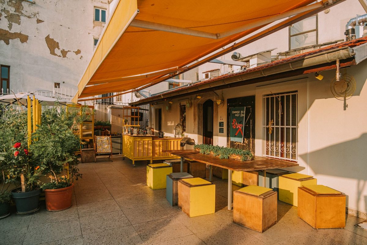 Store banne orange déployé au-dessus d'une terrasse de café