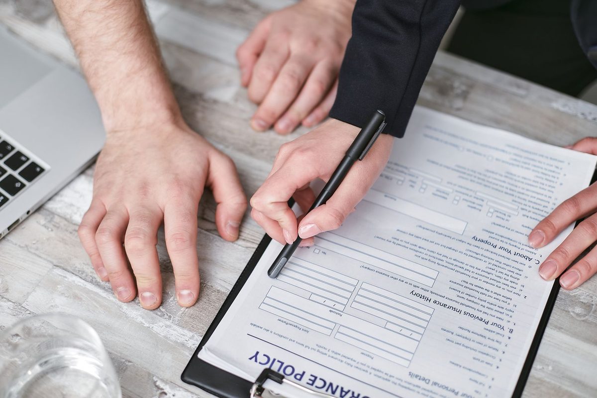 Deux personnes signant un contrat d'assurance sur un bureau