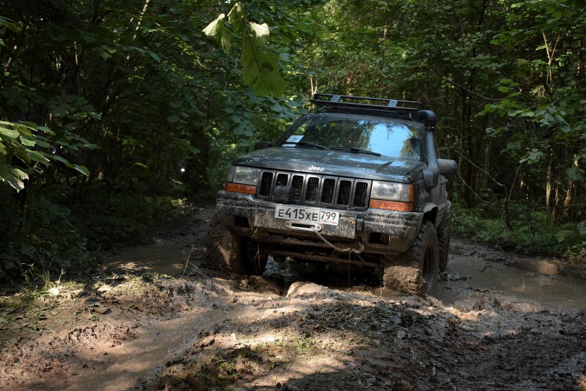 4x4 franchissant un chemin boueux en forêt