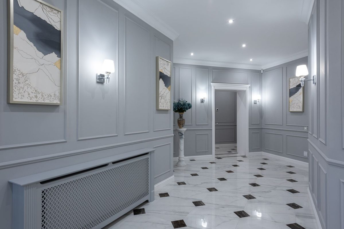 Couloir gris éclairé par des appliques murales de part et d'autre