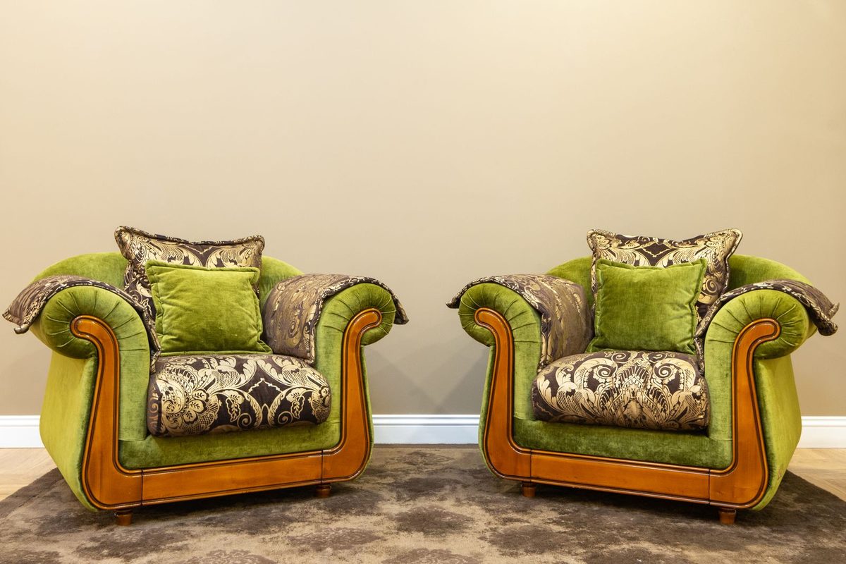 Deux fauteuils anciens retapissés dans un tissu vert à motifs