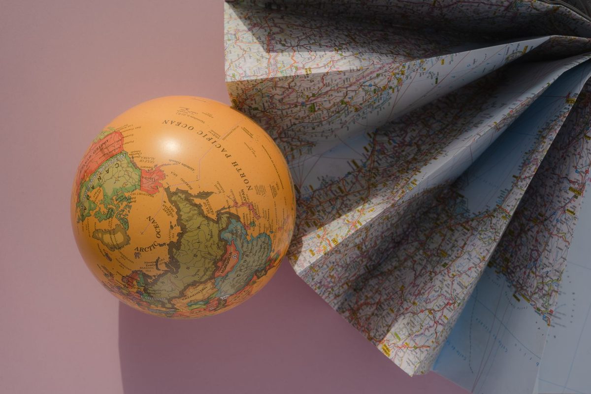 Globe terrestre posé sur des cartes routières dépliées