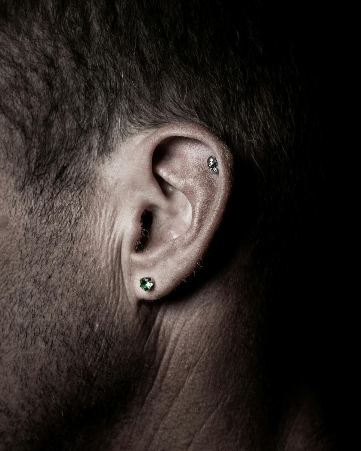 Oreille avec un piercing industriel reliant l'hélix et l'anti-hélix
