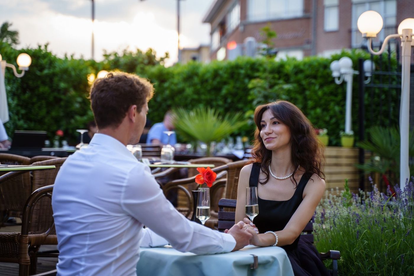 Couple dînant en terrasse d'un restaurant à la tombée du jour
