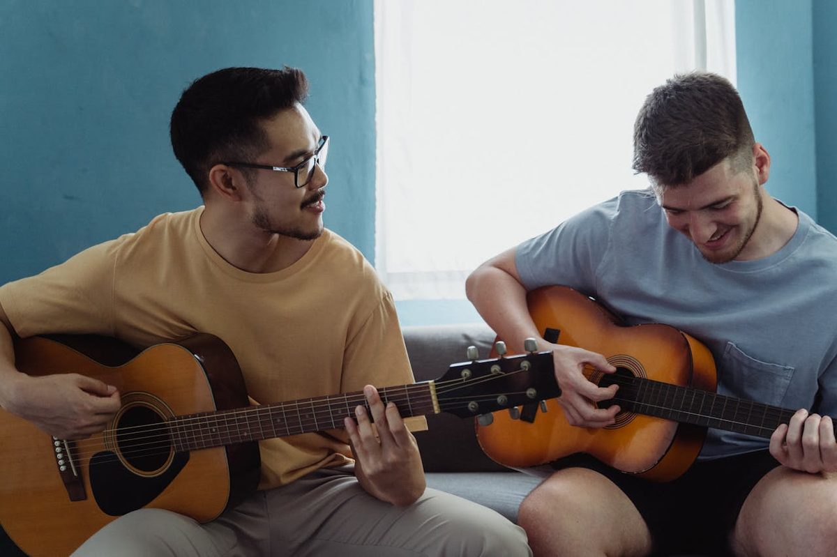 Adulte tenant une guitare acoustique lors d'une leçon de musique