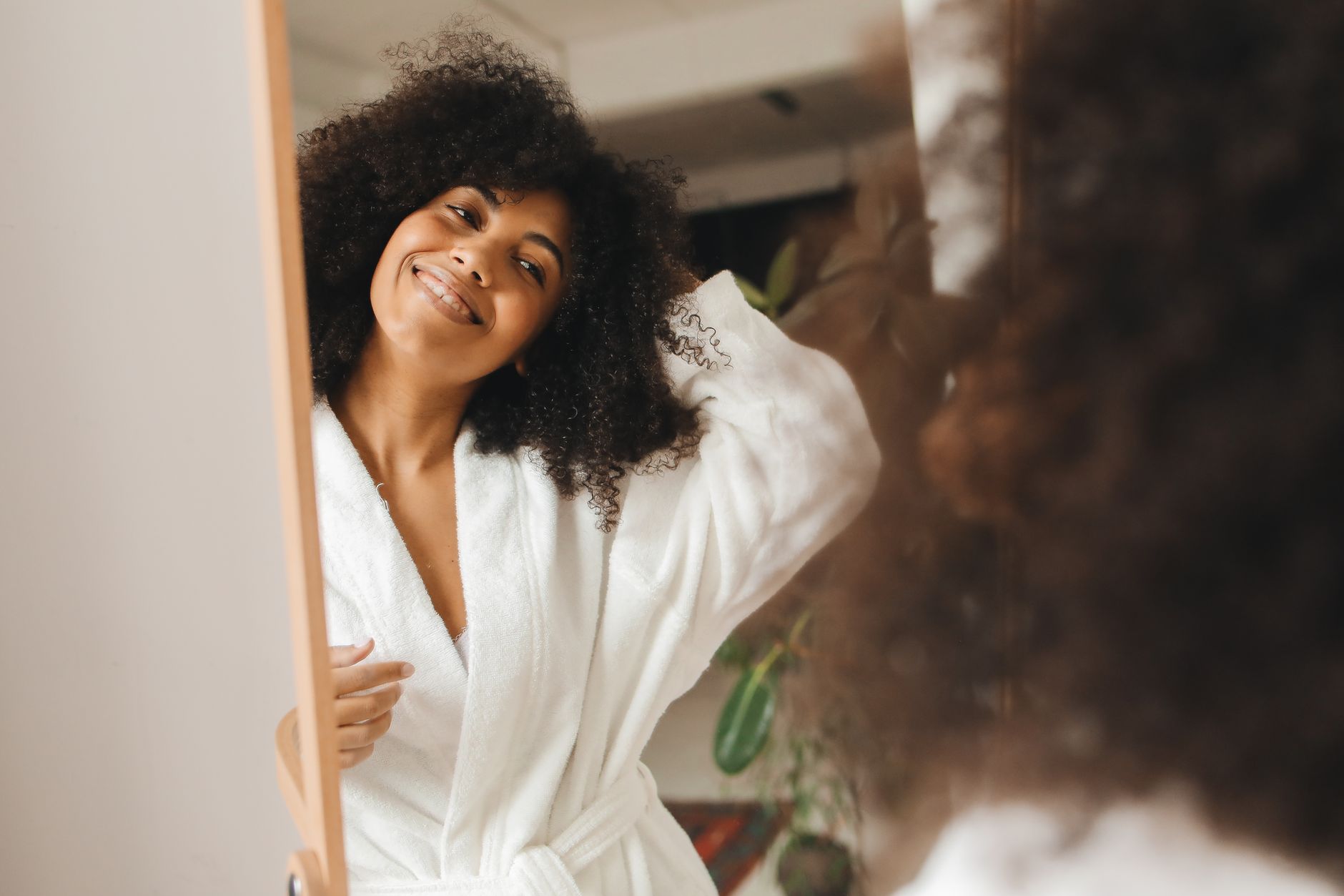 Femme prenant soin de ses cheveux naturels bouclés avec des soins adaptés