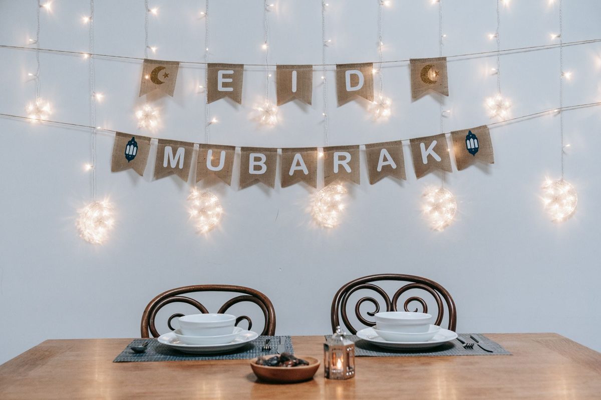 Guirlande « Eid Mubarak » et guirlande lumineuse au-dessus d'une table dressée