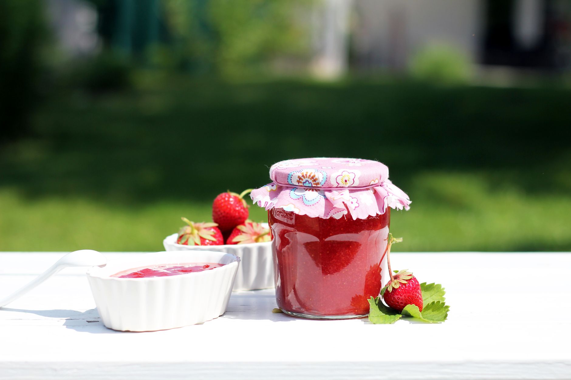 Pot de confiture maison aux fraises et fruits rouges, cuillère en bois