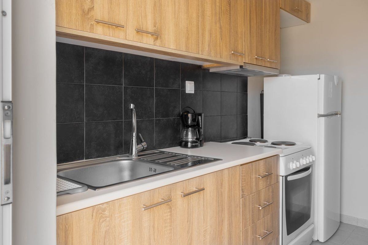 Cuisine équipée en bois clair avec plaque, four et évier intégrés