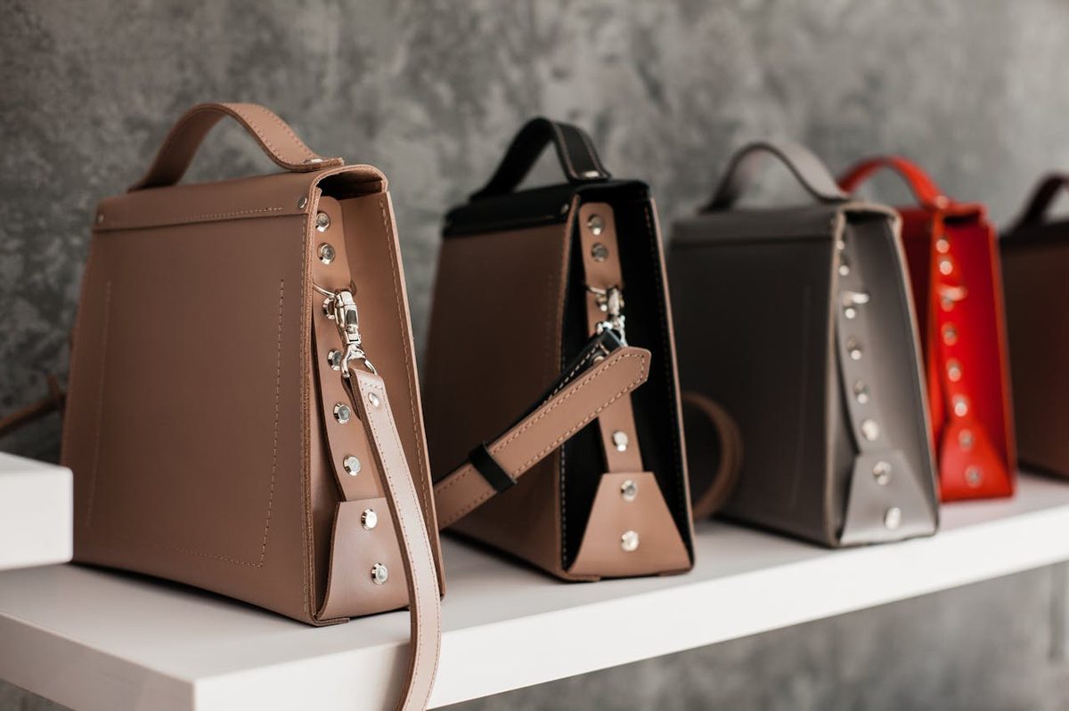Sac en cuir brun posé sur une surface en bois avec produits d'entretien