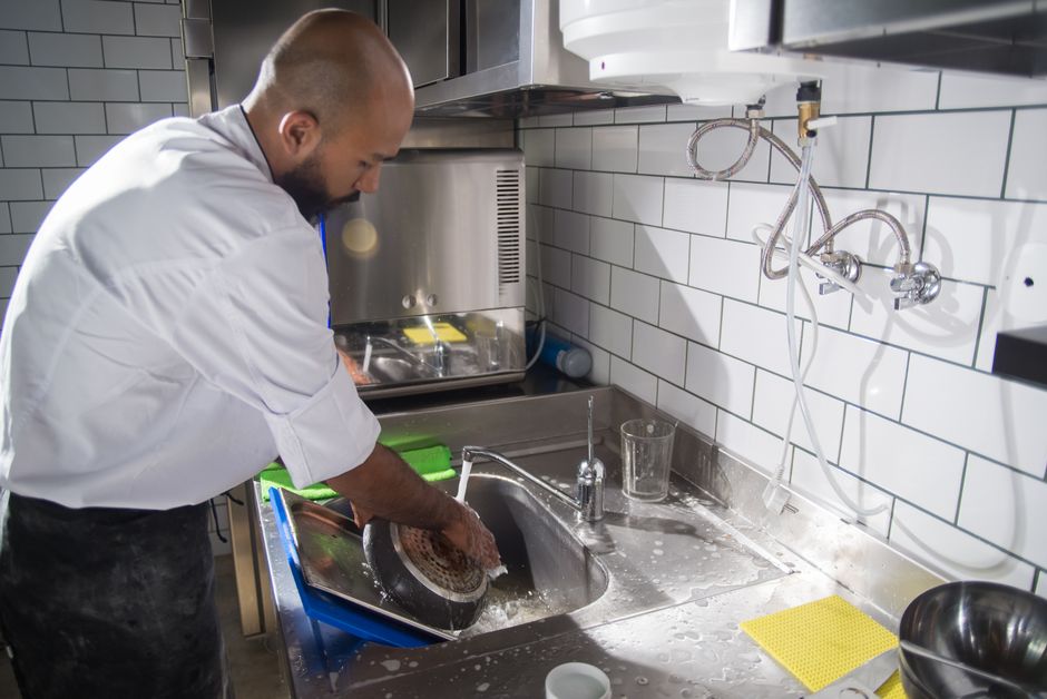 Chef cuisinier en cuisine professionnelle respectant les normes d'hygiène