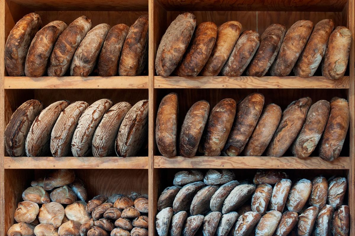 Étagères de boulangerie garnies de pains de formes variées