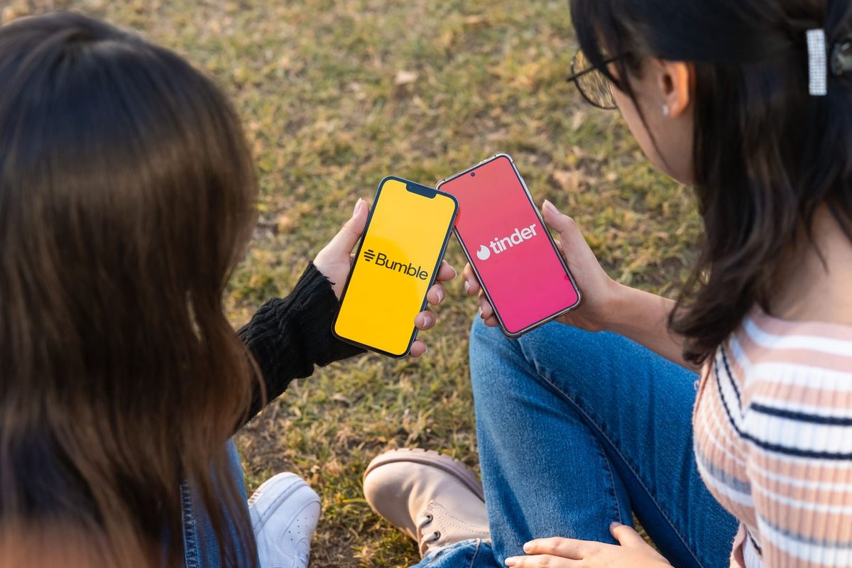 Deux personnes consultant les applications Bumble et Tinder sur leurs téléphones