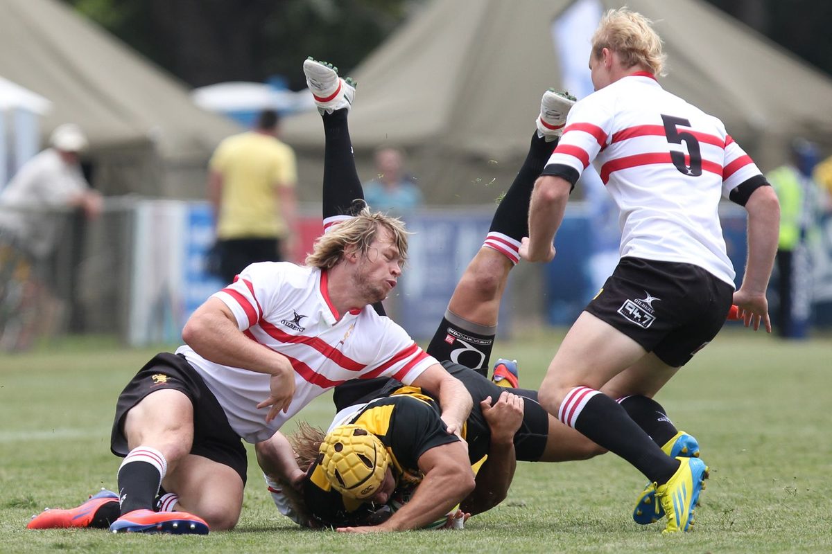 Joueurs de rugby au contact sur un terrain herbeux