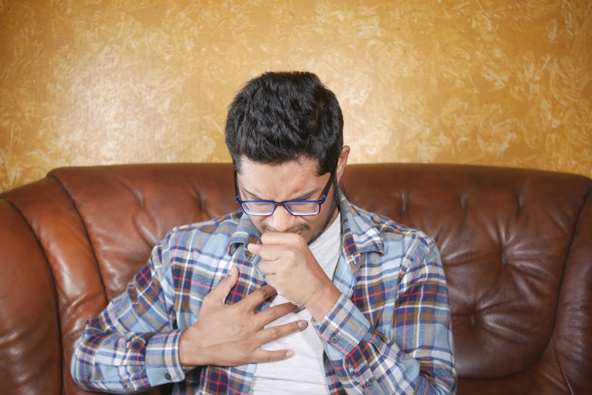 Personne se touchant la gorge en signe d'irritation