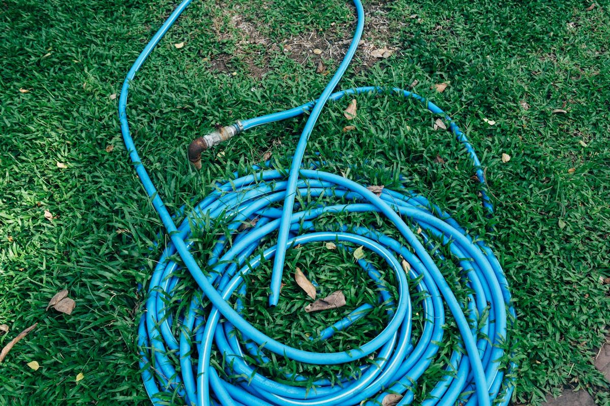 Tuyau d'arrosage enroulé dans un jardin
