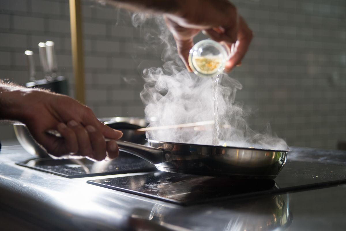 Poêle fumante sur une plaque de cuisson dans une cuisine moderne