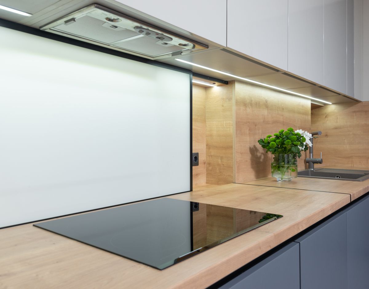 Plaque de cuisson encastrée sous une hotte aspirante dans une cuisine moderne