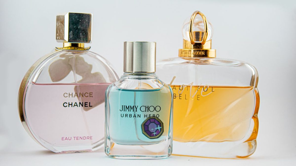 Plusieurs flacons de parfum sur une coiffeuse avec lumière dorée