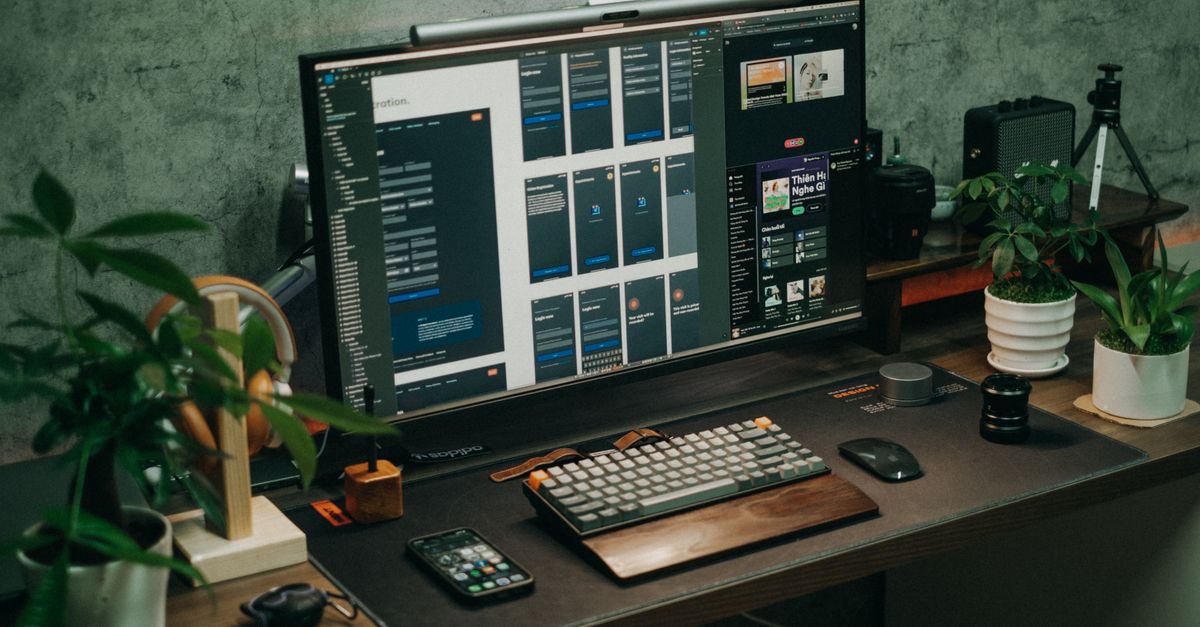 Bureau organisé avec écran, clavier et plantes vertes