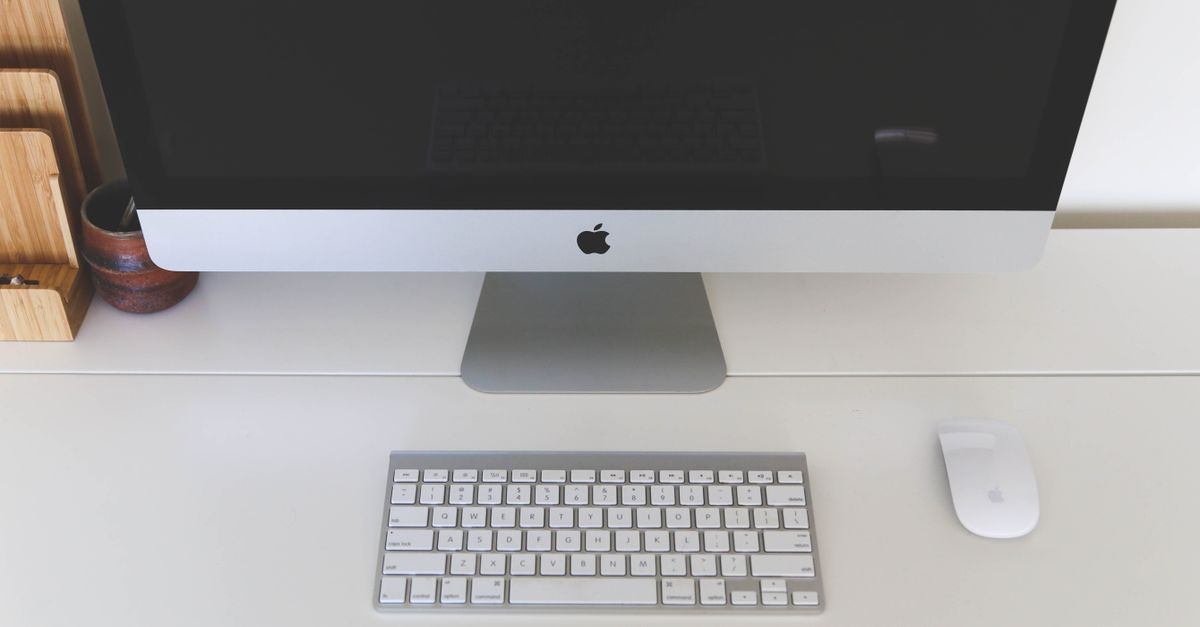 Ordinateur iMac argenté avec clavier et souris Apple
