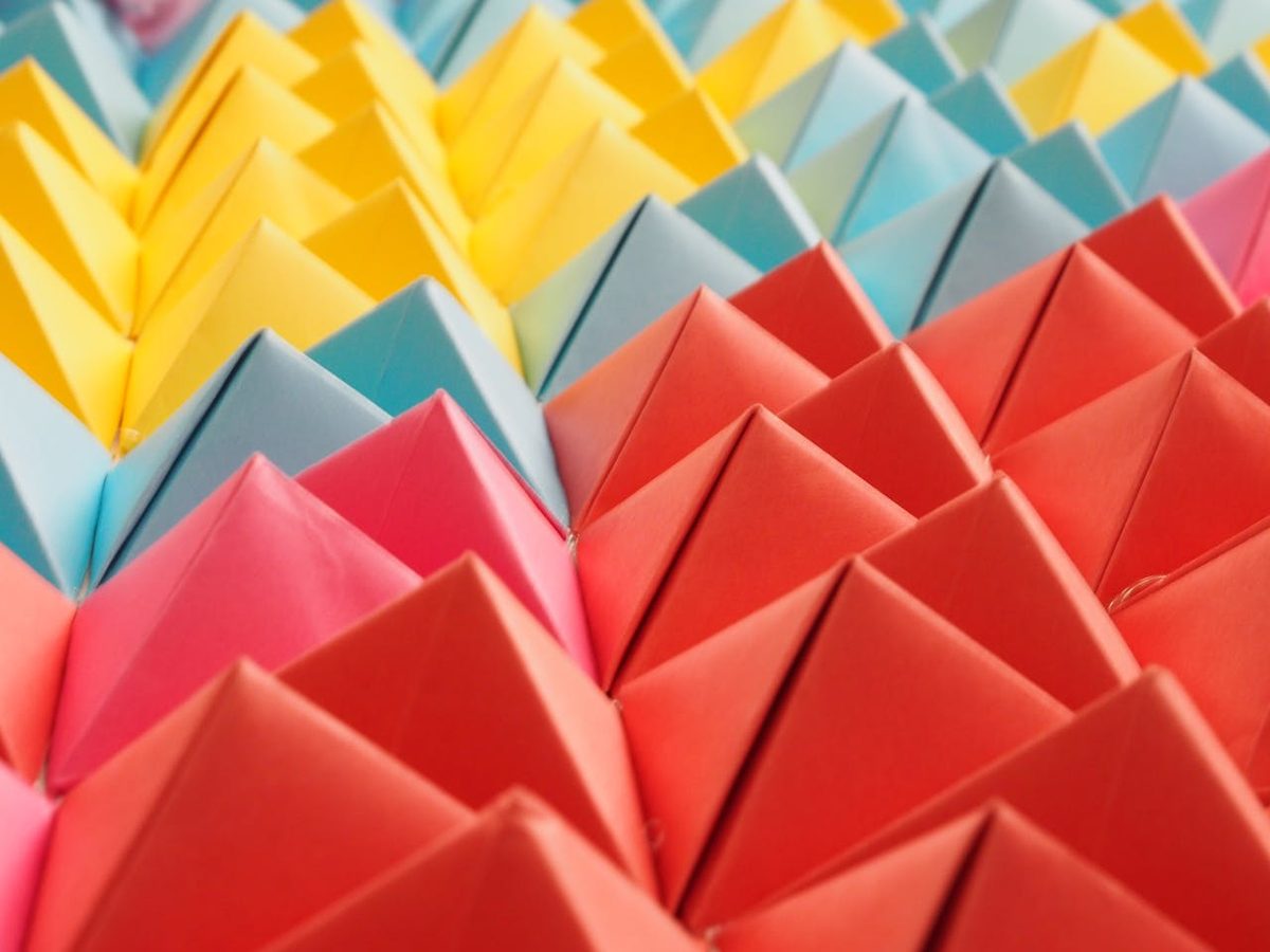 Plusieurs figures en origami colorées sur une surface en bois