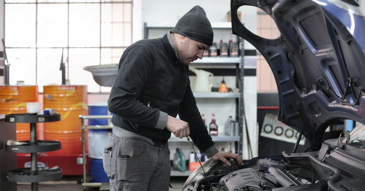 Mécanicien vérifiant le moteur d'une voiture