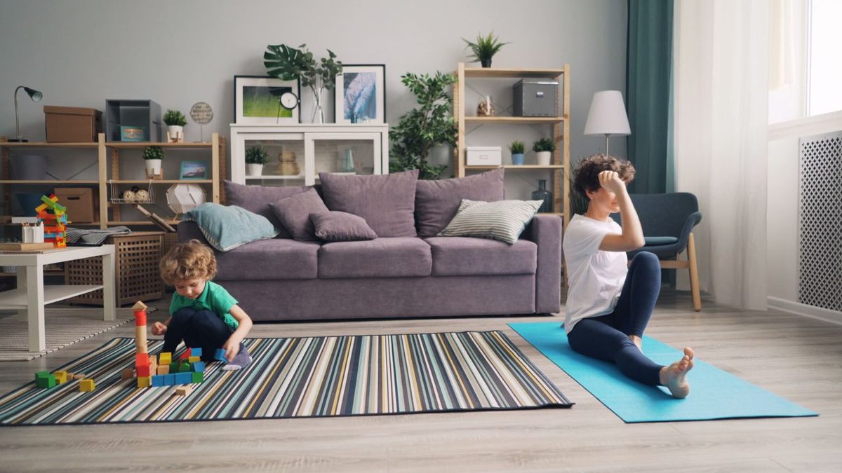 Personne faisant du yoga sur tapis dans un salon lumineux