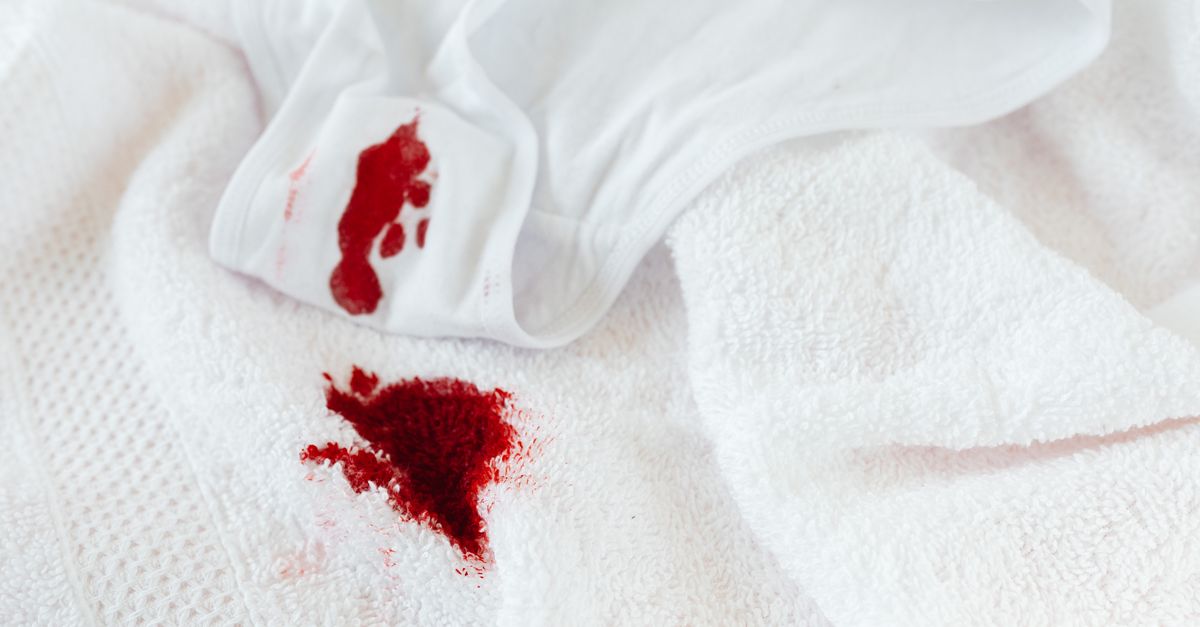Tache de vin rouge sur une nappe blanche avec un torchon pour tamponner