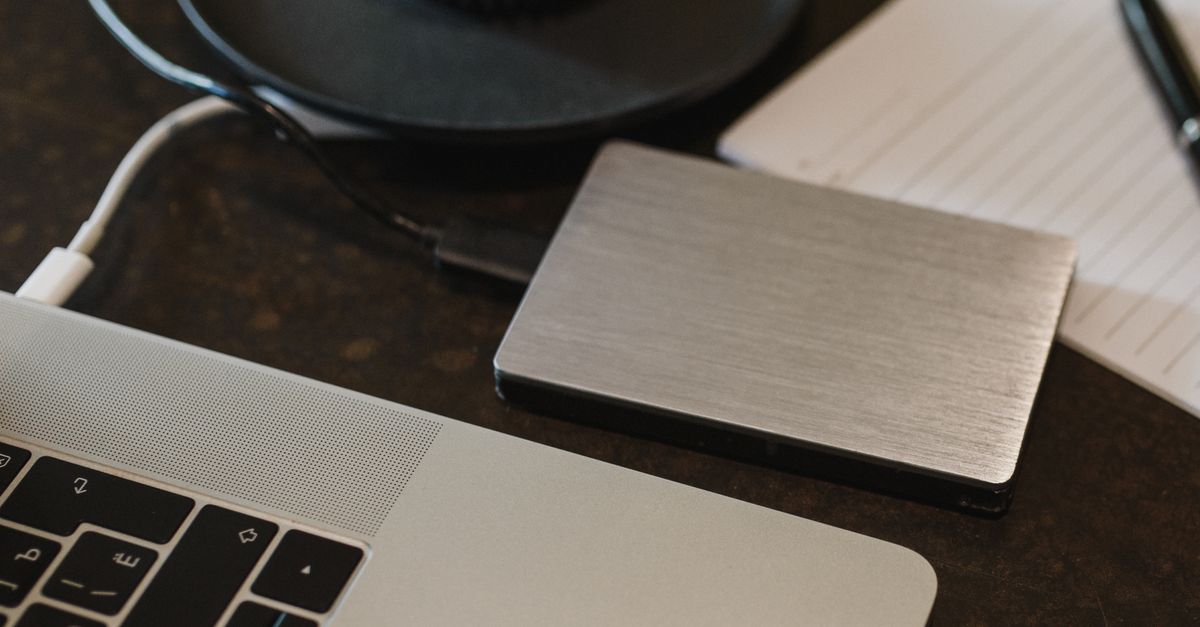 Disque dur externe posé à côté d'un ordinateur portable ouvert