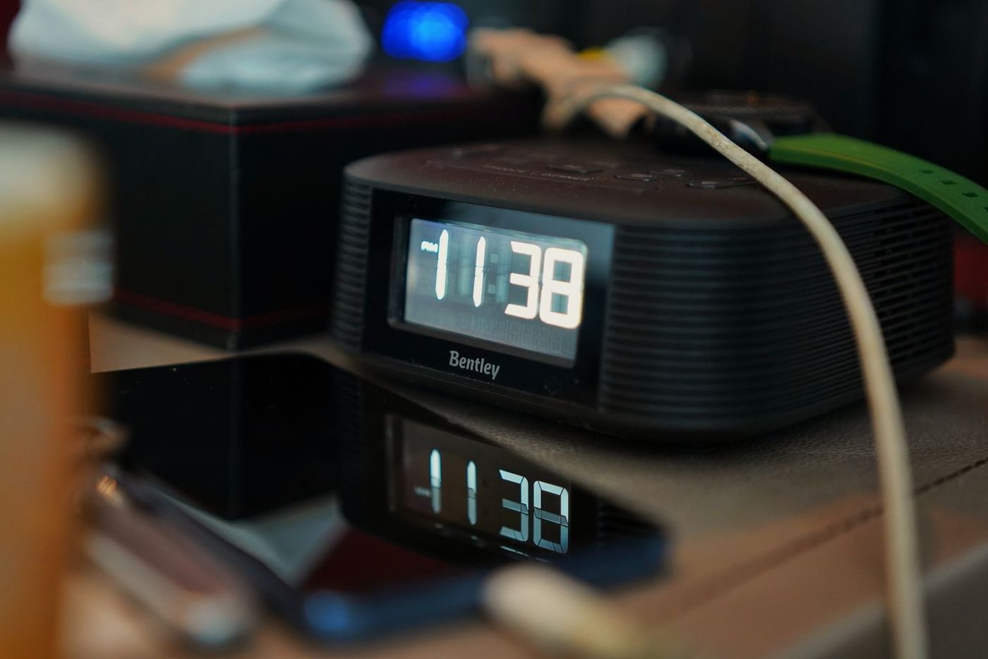 Radio-réveil numérique allumé sur une table de nuit en fin de soirée