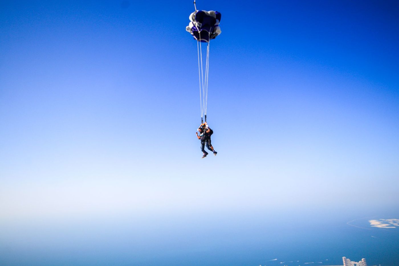 Saut en parachute en tandem sous voile ouverte, au-dessus de la mer